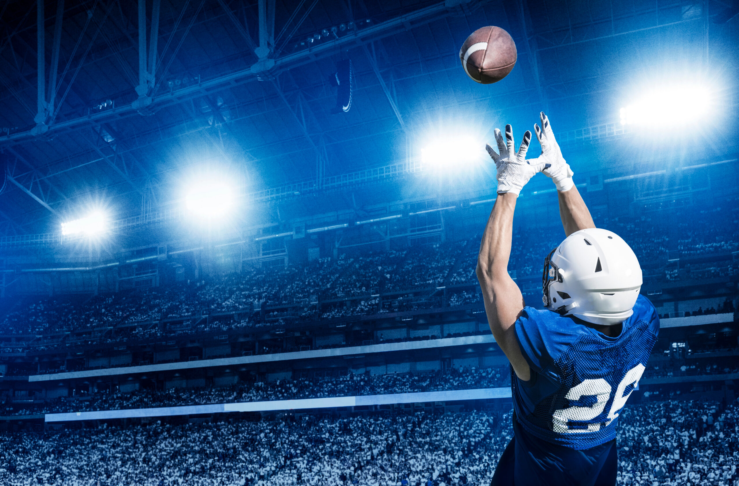 American Football Player Catching a touchdown Pass in a large st